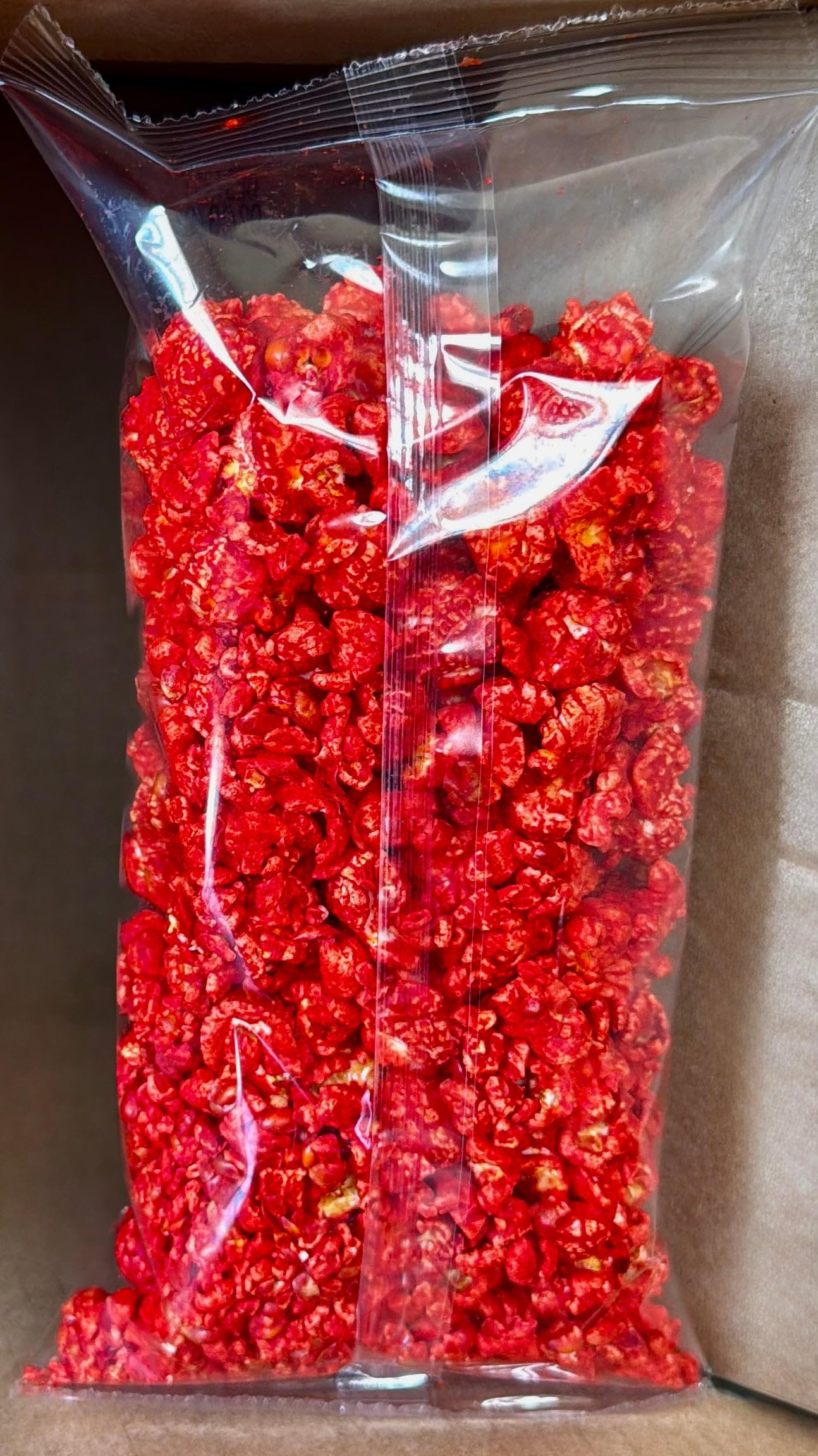 Hot Junior Snacks Co. Hot Cheddar in a clear bag showcasing bold red color and crispy textures.