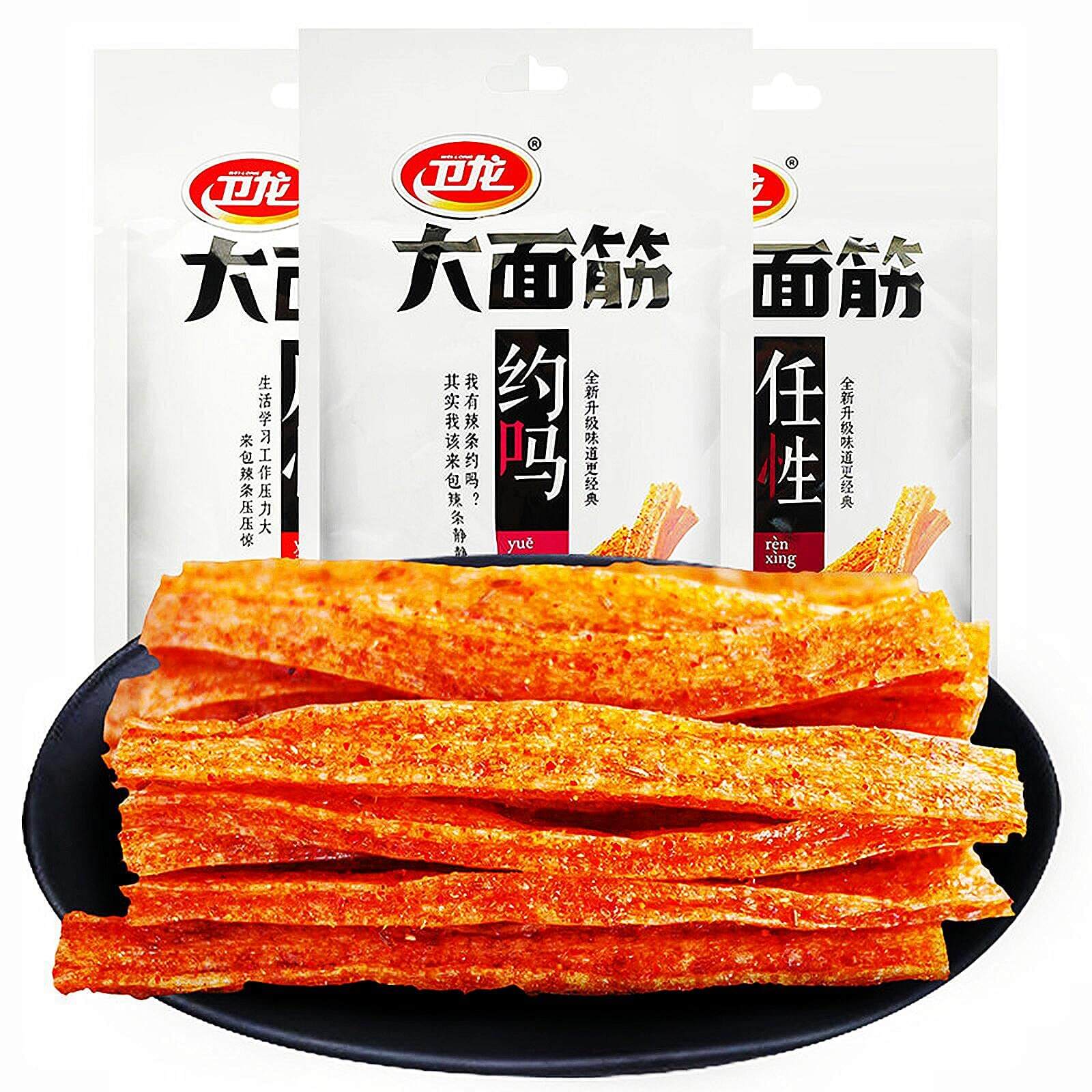 Chinese Spicy Latiao Gluten Strips in a black bowl with packaging in the background. Viral TikTok Chinese Latiao